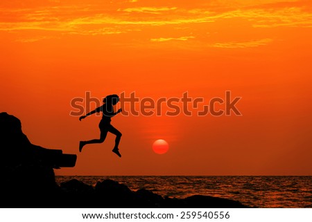 silhouette jumping woman at the beach when sunset in freeday