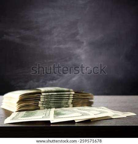 blackboard and space for text with dollars on dark top of furniture 