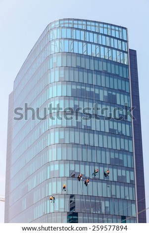 Washers wash the windows of modern skyscrape Royalty-Free Stock Photo #259577894