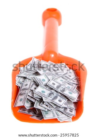 toy shovel full of dollars isolated on white