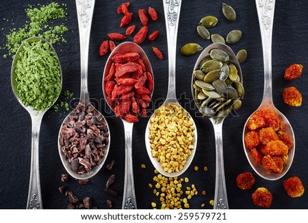 Spoons of various superfoods on black background Royalty-Free Stock Photo #259579721