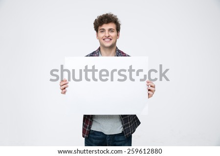 Happy man with curly hair holding blank billboard
