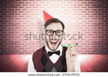 Geeky hipster in party hat with horn against grey background with vignette