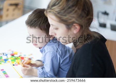 Close-up of mother and son enjoying alphabet puzzle at home