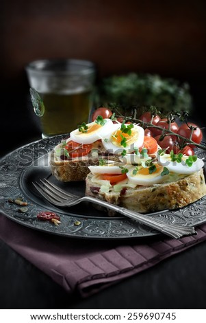 Open egg and cress sandwich with farmhouse loaf with cranberries, sunflower and pumpkin seeds against a rustic setting. Perfect image for your menu cover design. Copy space.