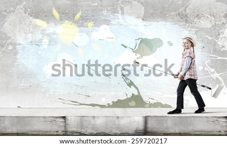 Cute girl of school age painting wall with roller