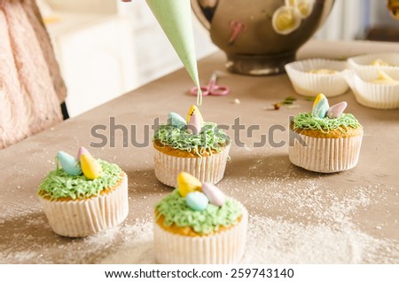 Beautiful cute Easter cupcakes  with Easter decorations isolated on wood background while cooking by chef