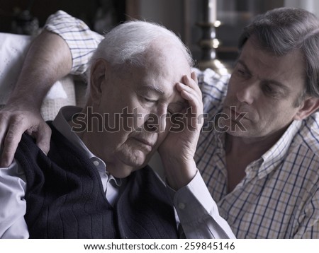 Portrait of an elderly man, comforted by his son Royalty-Free Stock Photo #259845146