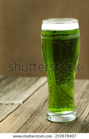 Green beer in glass for st. Patricks day on vintage background with toning