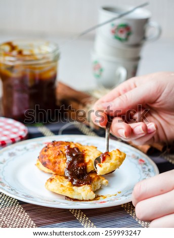 baked  cottage cheese pancakes with caramel on a white background, eating a teaspoon, dessert