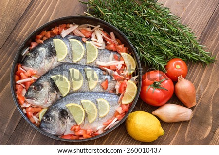 Raw fish with vegetables in a dish before cooking. Royalty-Free Stock Photo #260010437