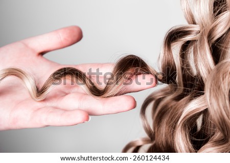 strand of curly blond hair on his arm Royalty-Free Stock Photo #260124434