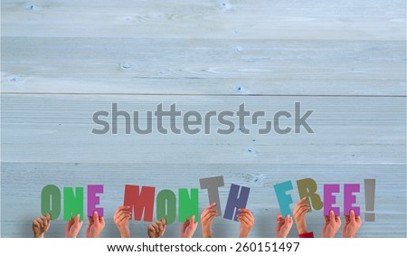 Hands holding up one month free against bleached wooden planks background