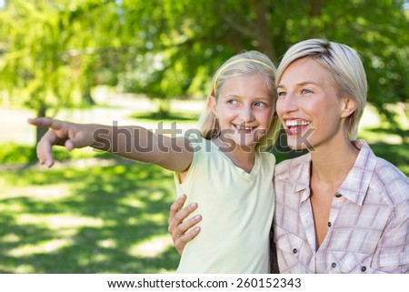 Happy blonde with her daughter in the park on a sunny day