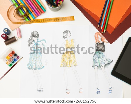 top view of desk with fashion designing equipment and sketches