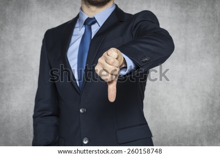 Businessman pointing thumbs down