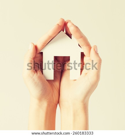 pisture of woman hands holding paper house