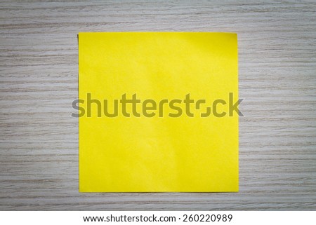Yellow sticky note attach to a wooden wall