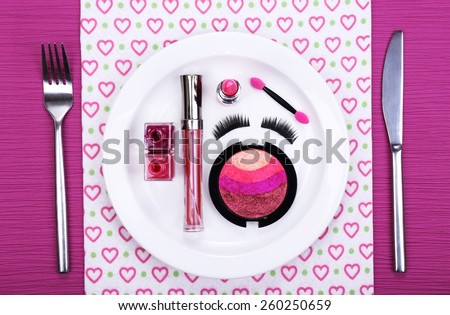 Makeup accessories on plate on colorful background