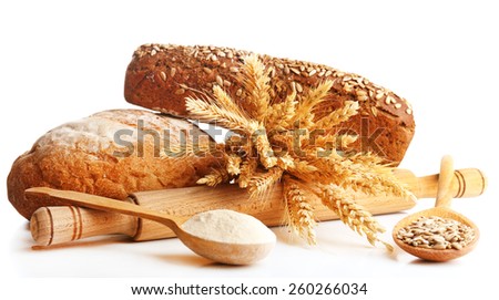 Fresh bread with wheat, flour and sunflower seeds in wooden spoons isolated on white