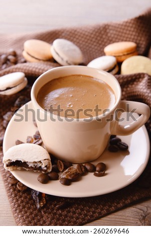 Gentle colorful macaroons and  coffee in mug on wooden table background