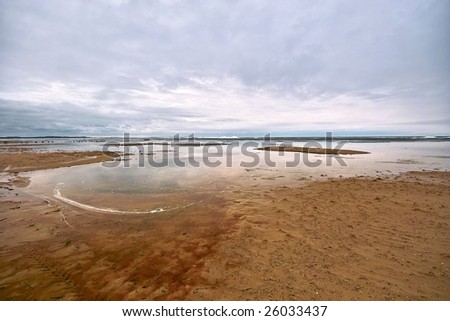 Shallow and sandy beach of the lake in winter