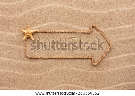Arrow made of rope and sea shells with the word Tahiti on the sand, as background
