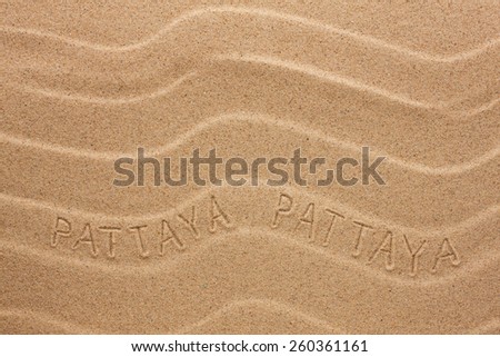 Pattaya  inscription on the wavy sand, as background