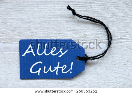 Blue Label Or Tag With Black Ribbon On White Wooden Background With German Text Alles Gute Which Means Best Wishes Vintage Retro Or Rustic Style
