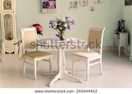 dining room interior with flowers decorative plates on  wall and tea cup