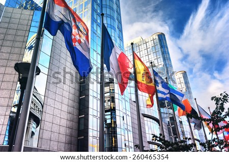 Waving flags in front of European Parliament building. Brussels, Belgium