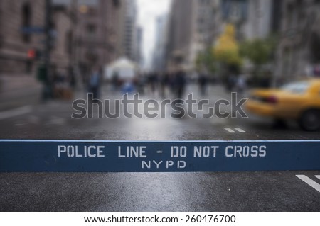 Police Line Do Not Cross. A Police line do not cross police department crime scene sign on the sidewalk in New York City. Blur background. Royalty-Free Stock Photo #260476700