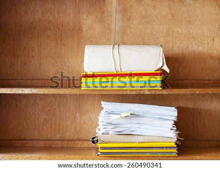 file folders and sheets of paper on the shelve background