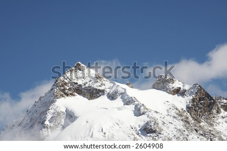 Snowcovered high cordillera mountain and clouds