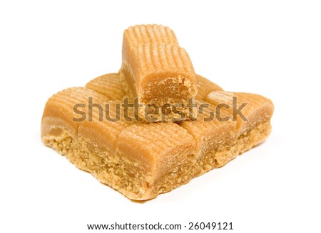 Several toffee in plate on white background