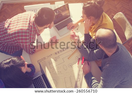 Young group of people/architects discussing business plans. Royalty-Free Stock Photo #260556710