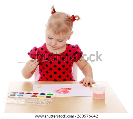 Girl makes drawing water color paints sitting at the table - isolated on white.