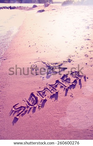 the word summer written in sand  with instagram effect retro vintage filter