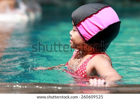 Asian baby girl playing in swimming pool