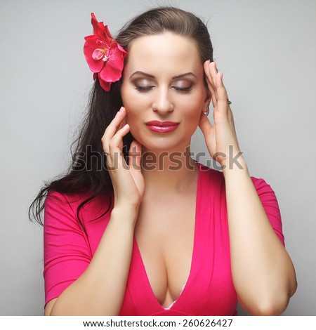 young happy woman with pink flower in the hair