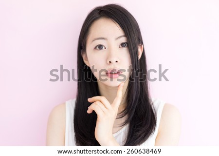beautiful young woman thinking against pink background