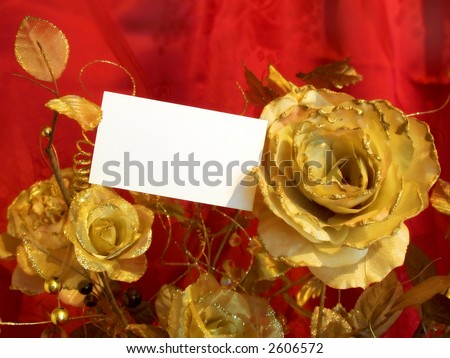 Golden roses and postcard on red background