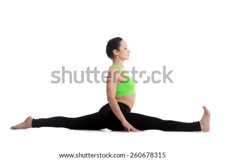 Slim sporty girl on white background sitting in splits, Monkey yoga pose, asana Hanumanasana, stretching practice