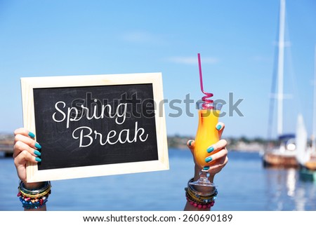 Spring break concept. Chalkboard in female hands on beach background