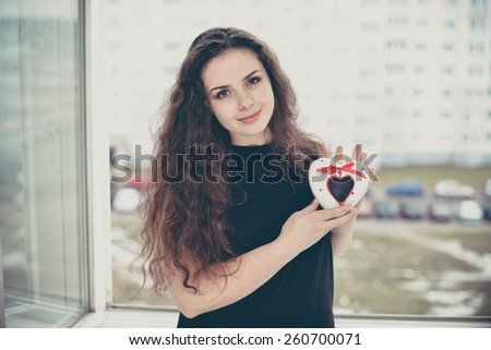 Pretty woman in love holding heart-shaped