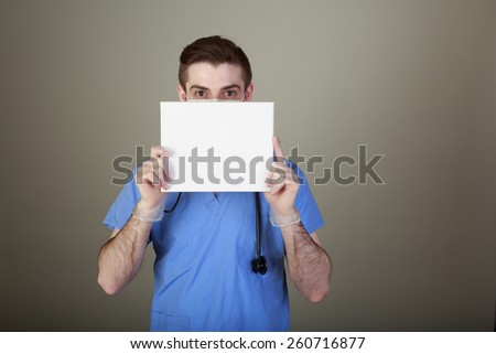 Infection Prevention concept shot of a doctor in mask and gloves holding up a sign with room for your own copy.