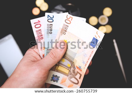 man's hand holding money on the black background