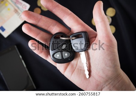 car keys on the man's palm on a black background