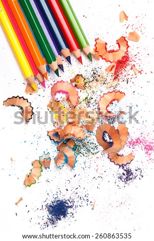 Multicolored pencils and shavings on white background