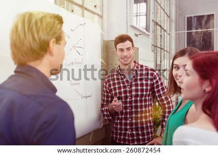 Young Male Leader Listening to his Colleagues During a Meeting About the Project at the White Board.